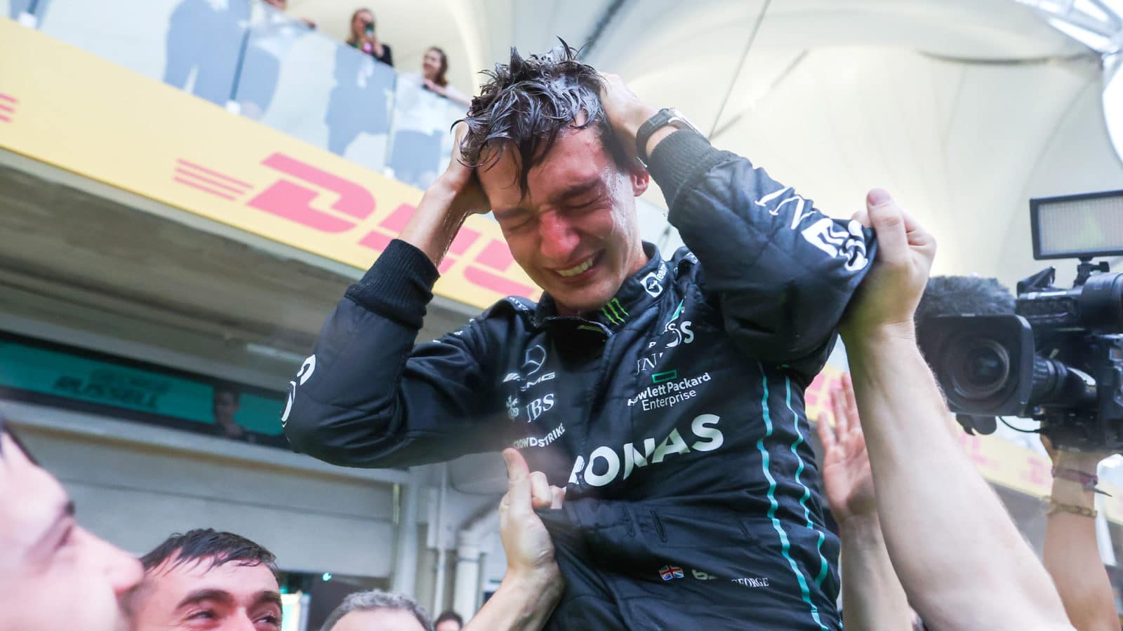 Tearful George Russell celewbrates winning his first Grand Prix with his team in Brazil