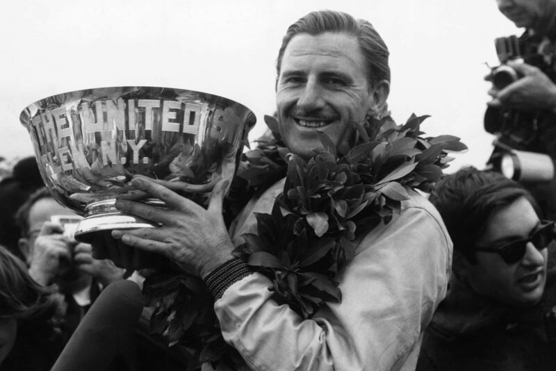 Graham Hill, BRM P261, holds his winner's trophy aloft.