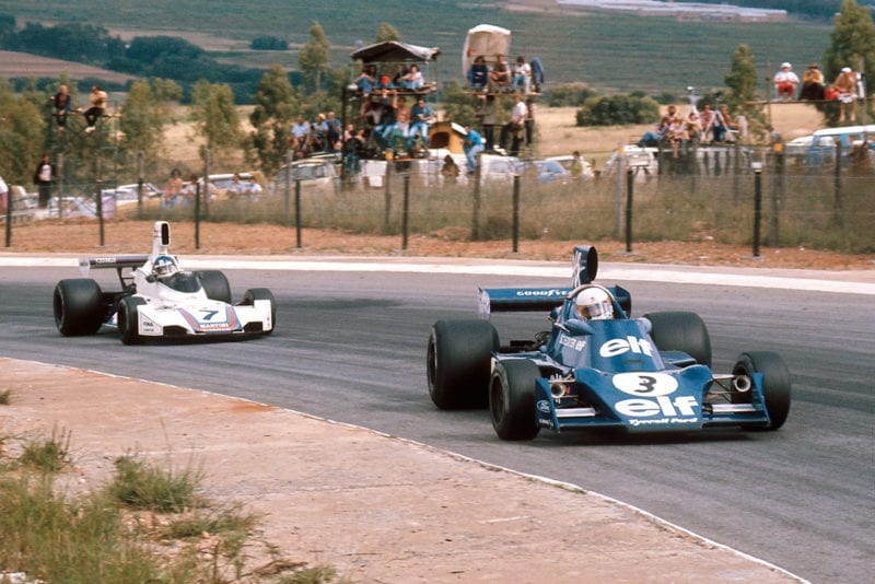 Jody Scheckter (Tyrrell) is chased By Carlos Pace (Brabham) at the 1975 South African Grand Prix, Kyalami.