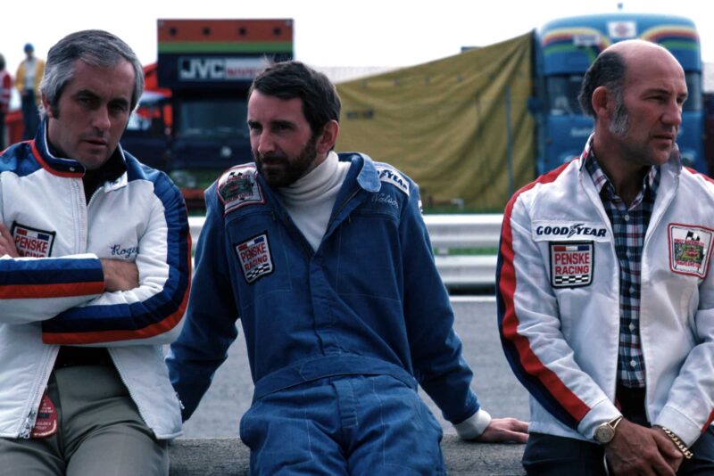 John Watson (centre) sits in between Roger Penske (left) and Stirling Moss (right).