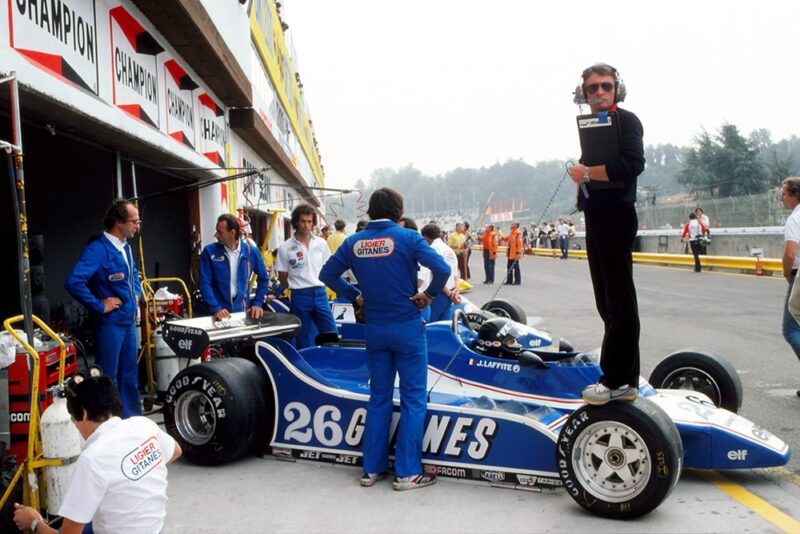 Ligier designer Gerard Ducarouge stands on the Gotti wheeled Ligier JS11/15 of Jacques Laffite.