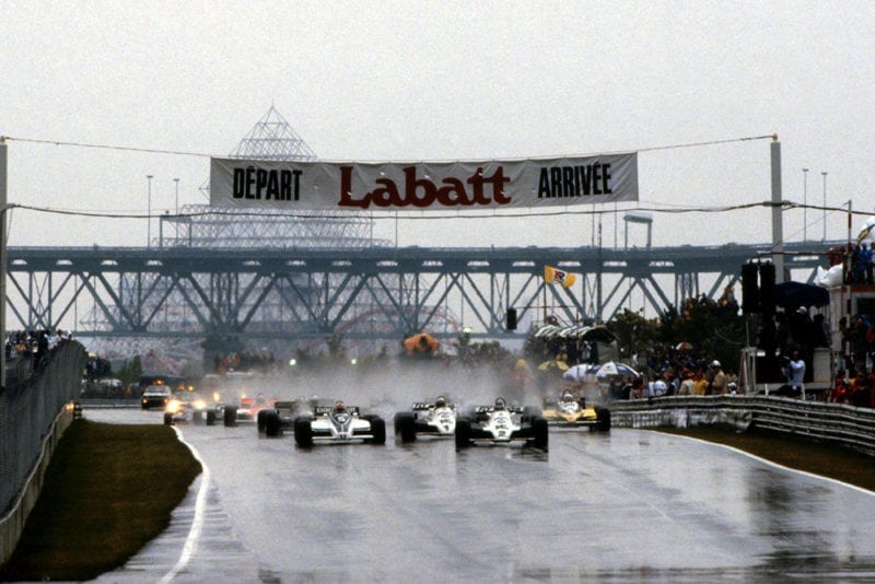 Carlos Reutemann in a Williams FW07C, leads from the line after starting from second on the grid.