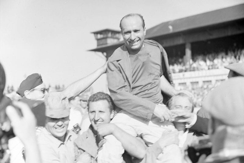 Juan Manuel Fangio celebrates with his team after winning the 1957 German Grand Prix and his fifth F1 title, Nurburgring