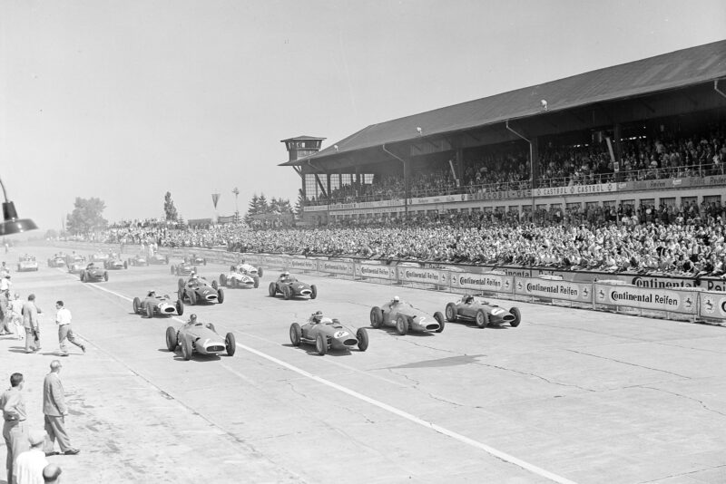 Juan Manuel Fangio, Maserati 250F, alongside Mike Hawthorn, Ferrari D50 (#8), Jean Behra, Maserati 250F (#2), and Peter Collins, Ferrari D50 (#7), at the start of the 1957 German Grand Prix, Nurburgring.