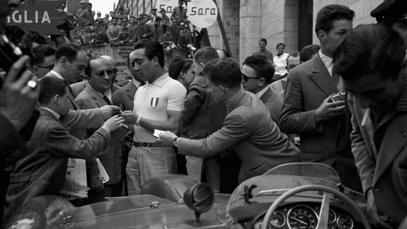 Eugenio Castellotti signs autographs during a stop at the 1956 Mille Miglia
