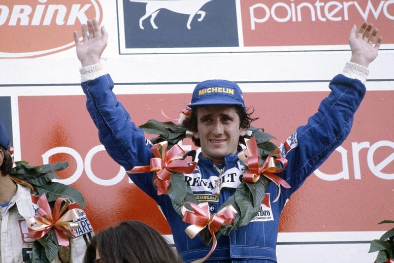 Alain Prost celebrates his win on the podium.