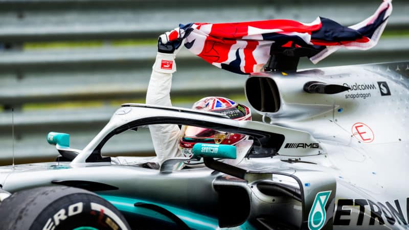 Lewis Hamilton waves the Union Jack from his Mercedes after winning the 2019 British Grand Prix