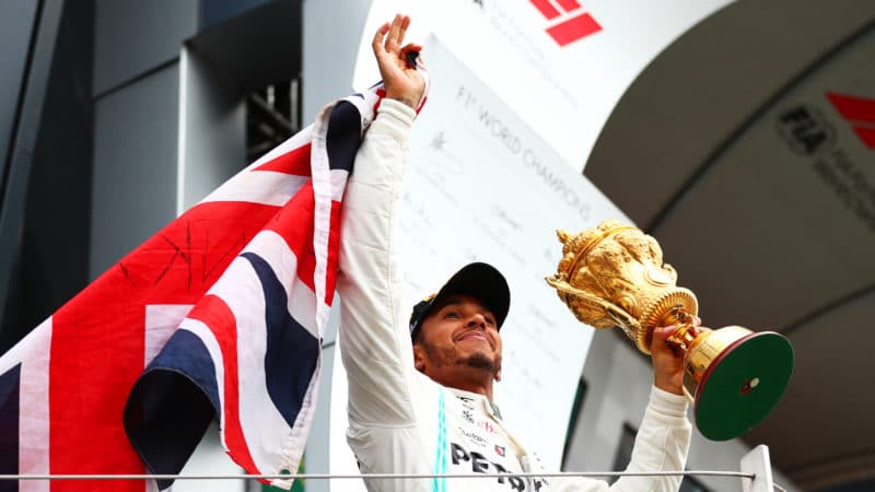 Lewis Hamilton with trophy and Union Jack after winning the 2019 British Grand Prix