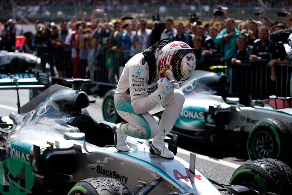 Lewis Hamilton crouches over his Mercedes after winning the 2015 British Grand Pris at Silverstone