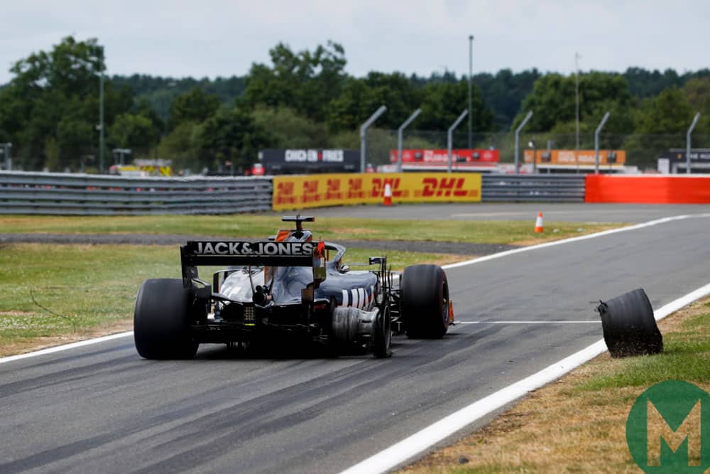 A wheel rolls off Romain Grosjean's damaged Haas at the start of the 2019 British Grand Prix
