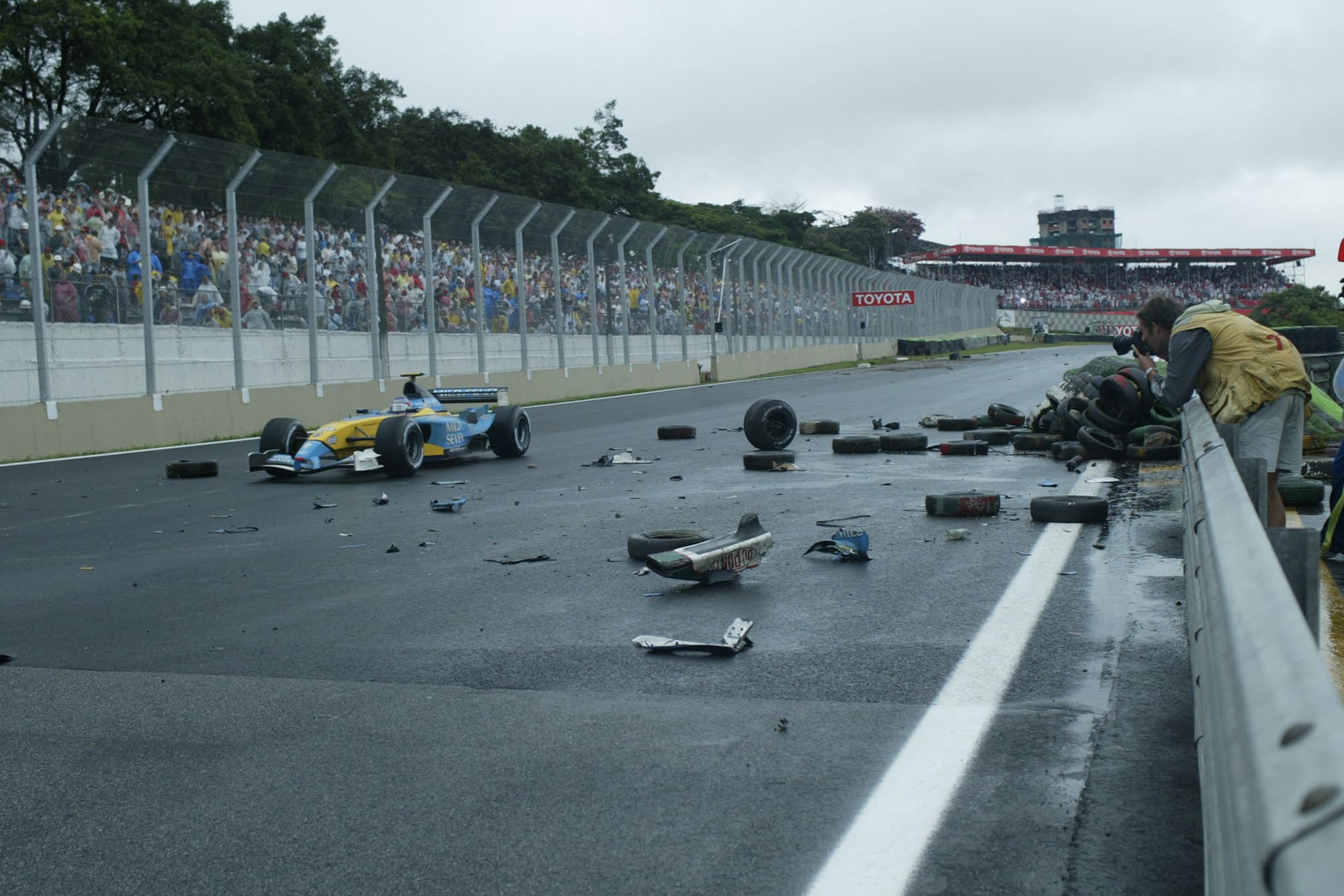 Jarno Trulli drives past crash debris in the 2003 F1 Brazilian Grand Prix