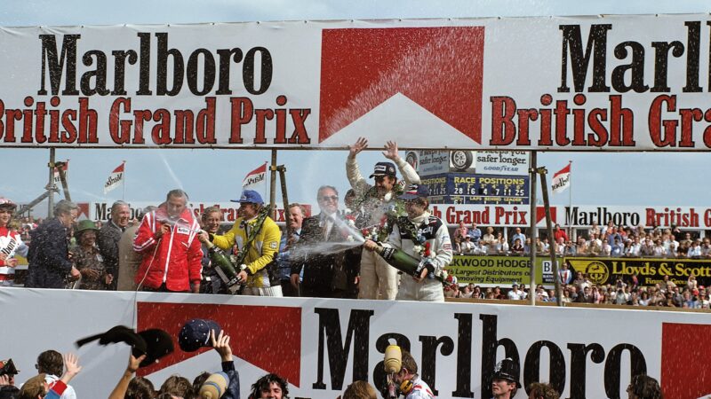 Clay Regazzoni celebrates Williams' forst win on the Silverstone podium at the 1979 British Grand Prix