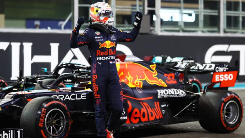 Max Verstappen stands next to his Red Bull with arms raised after claiming pole for the 2021 Abu Dhabi Grand Prix