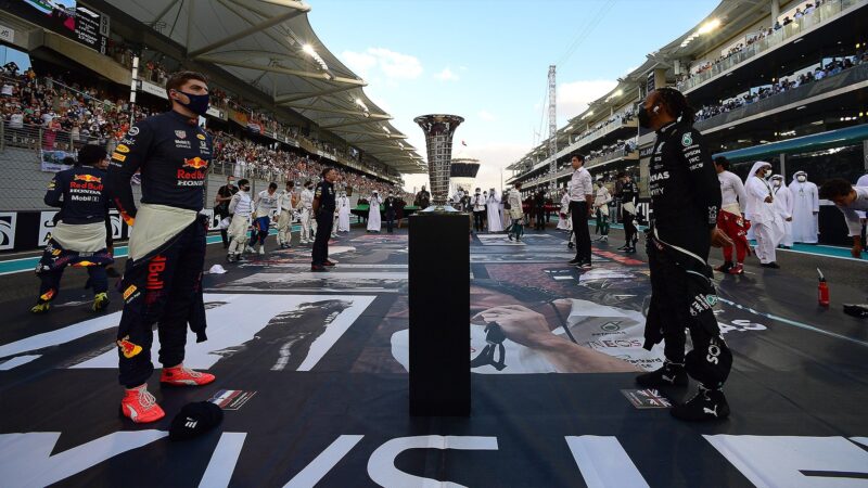 Max Verstappen and Lewis Hamilton either side of F1 world championship trophy