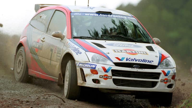 Colin McRae of Scotland in a Ford Focus WRC slides his car through the wet conditions before retiring with electrical failure on the first full day of the Rally of New Zealand outside Auckland 16 July 1999. World Champion Tommi Makinen of Finland in a Mitsubishi Lancer EVO leads Frenchman Didier Auriol by 1 minute and 15 seconds after nine of the day's ten special stages with Finland's Juha Kankkunen in a Subaru Impreza WRC 1 minute 27 seconds behind the leader in third position. AFP PHOTO/Andrew CORNAGA (Photo by ANDREW CORNAGA / AFP) (Photo credit should read ANDREW CORNAGA/AFP via Getty Images)