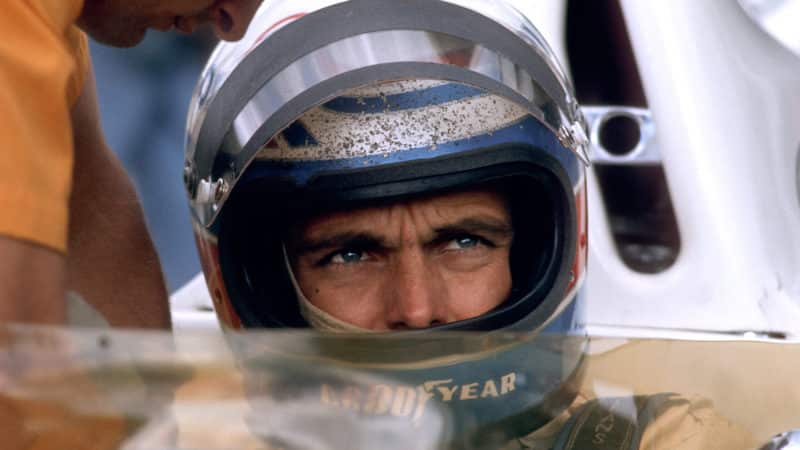 Peter Revson in stone-spattered helmet at 1973 British GP