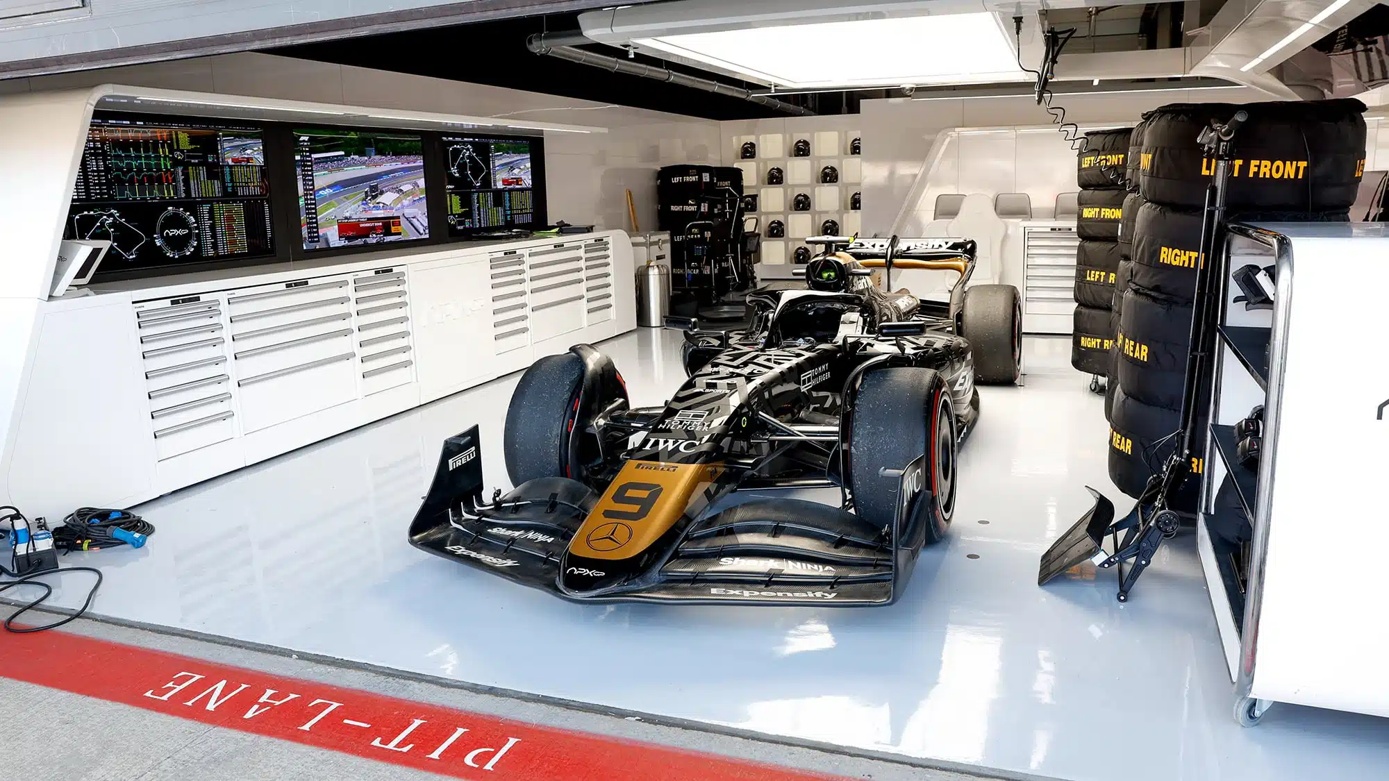 APXGP black and gold car in pit garage at 2023 British Grand Prix