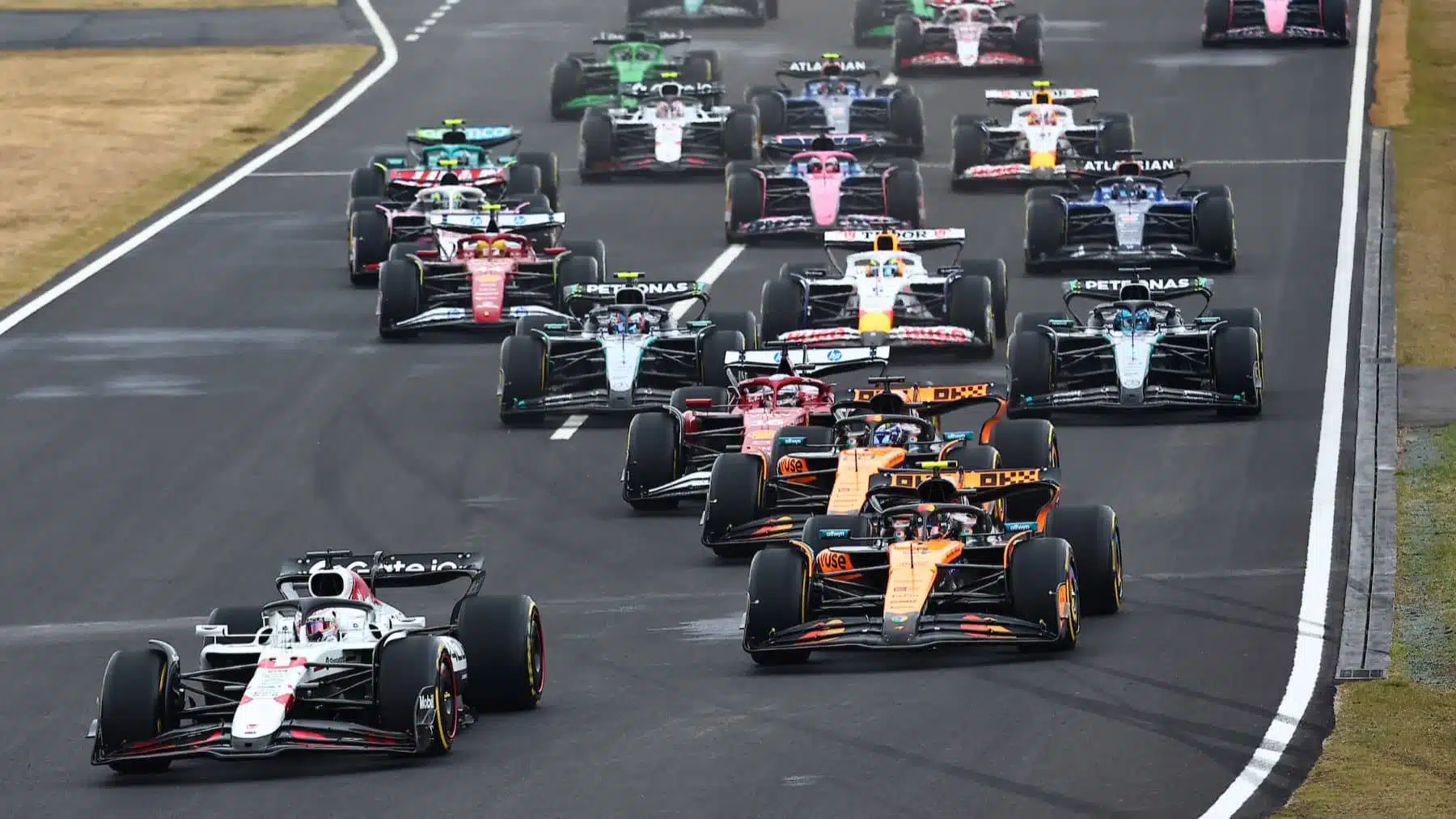 Max Verstappen (Red Bull-Honda) and Lando Norris (McLaren-Mercedes) lead the field at the start of the 2025 Japanese Grand Prix in Suzuka