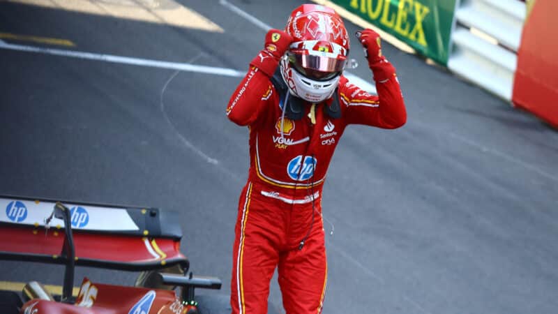 A cheering Charles Leclerc (Ferrari) on his car with helmet on after winning the 2024 Monaco Grand Prix