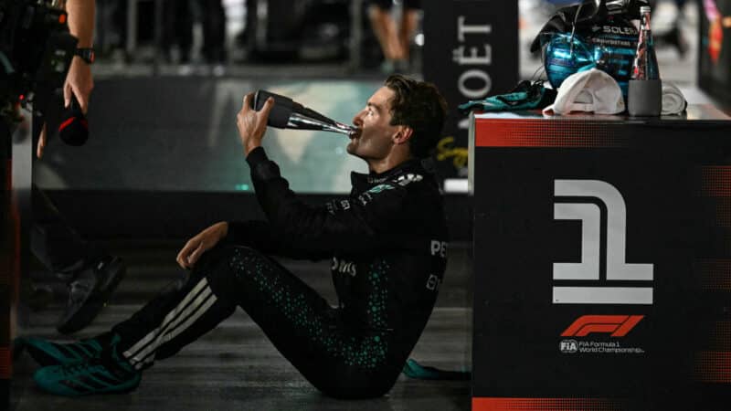 George Russell has a drinks as he celebrates his victory after the Formula 1 Singapore Grand Prix