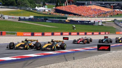 McLaren-Mercedes drivers Lando Norris and Oscar Piastri lead the field on the first lap after the start of the 2025 Austrian Grand Prix