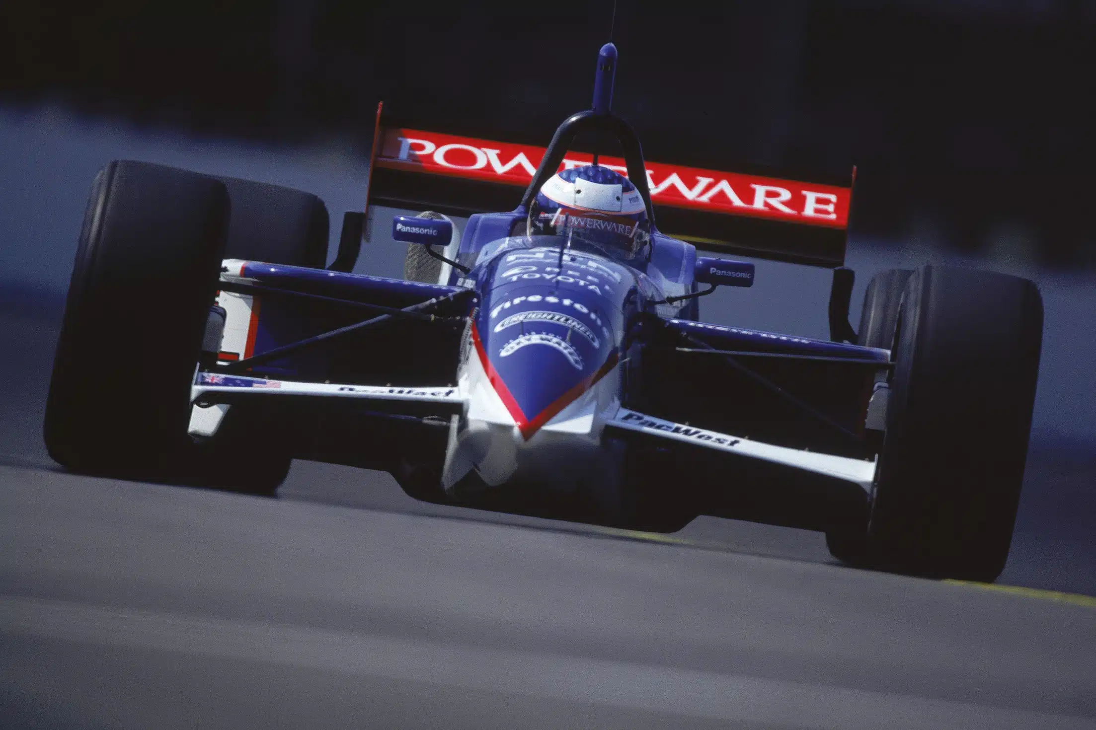 Blue white red POWERWARE Panasonic Firestone IndyCar front view racing at speed on track