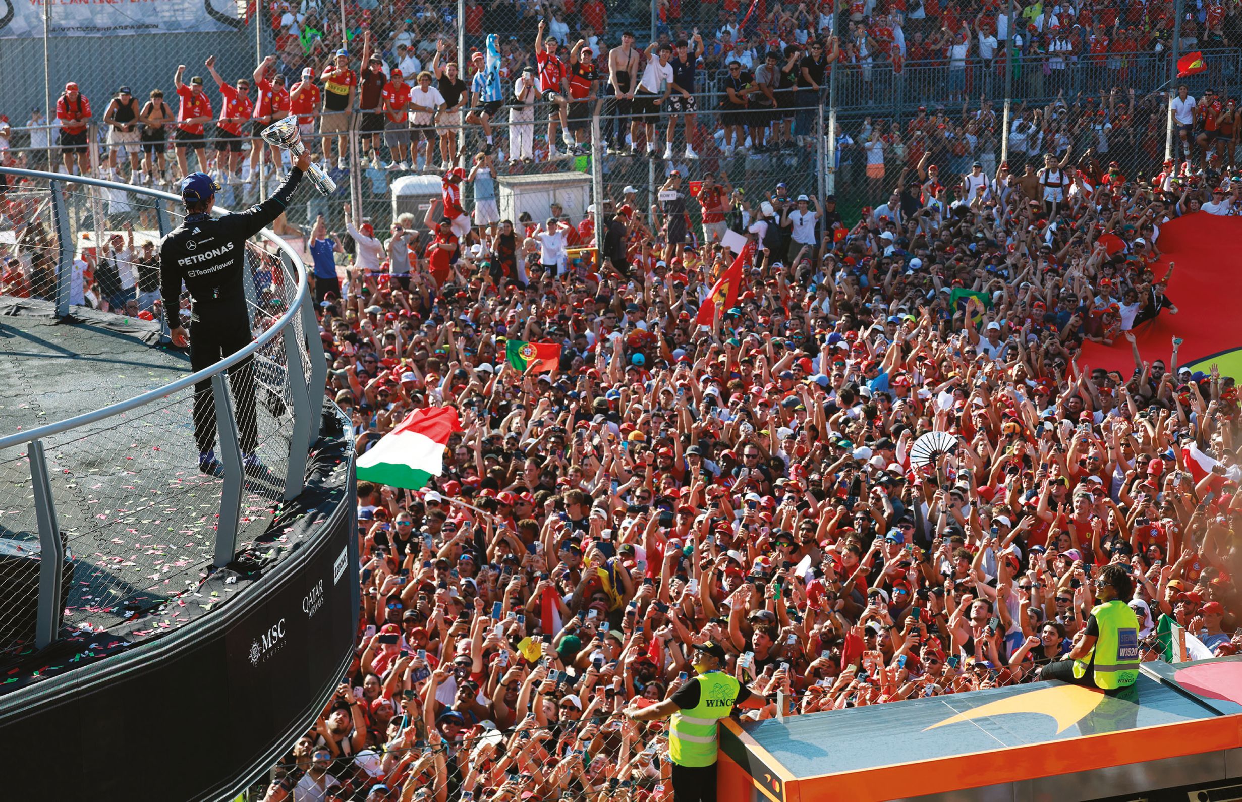 Kimi Antonelli celebrates with trophy before a packed crowd